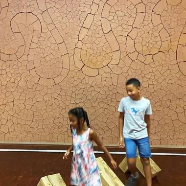 Deux enfants s'amusent au musée Gassendi dans la salle des paysages devant l'oeuvre d'Andy Goldsworthy