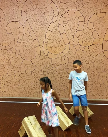 Deux enfants s'amusent au musée Gassendi dans la salle des paysages devant l'oeuvre d'Andy Goldsworthy