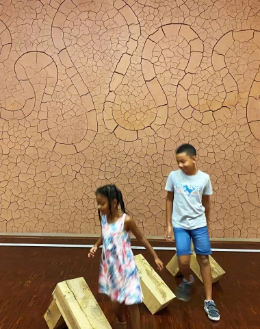 Zwei Kinder vergnügen sich im Gassendi-Museum im Landschaftsraum vor dem Werk von Andy Goldsworthy