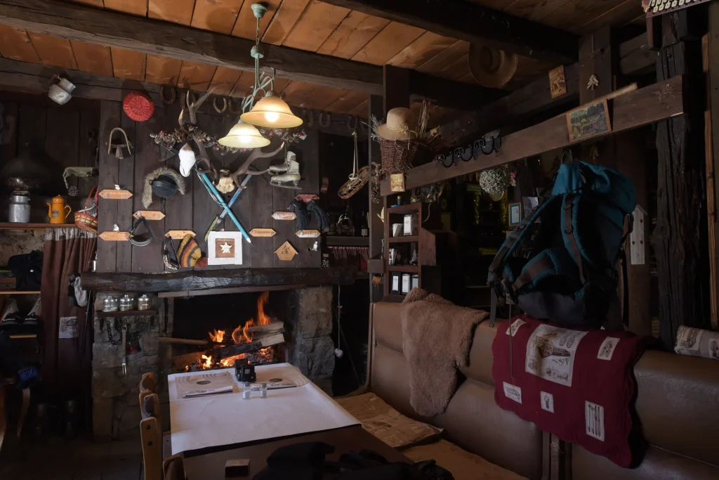 Salle à manger avec feu de cheminée dans le restaurant d'altitude les Clapeiries à Montclar